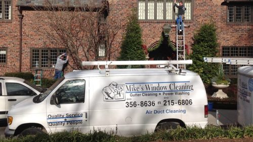 Mike's Window and Gutter Cleaning hard at work washing windows on Kansas City home