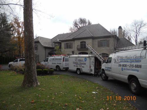 Trucks from Mike's Window and Gutter Cleaning parked outside of Kansas City home