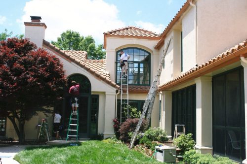 Window washing technicians from Mike's Window and Gutter Cleaning hard at work cleaning exterior windows on Kansas City home