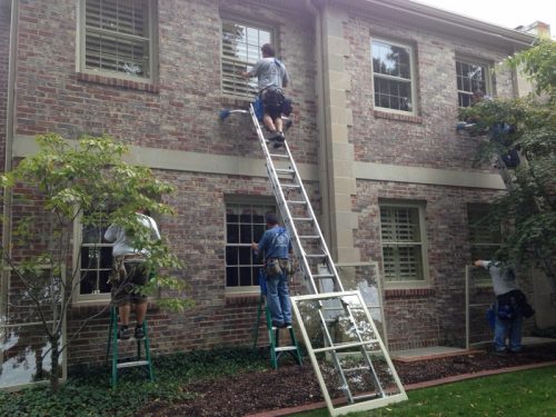 Team of window washers from Mike's Window and Gutter Cleaning hard at work on Kansas City home