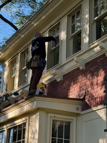 Window washer from Mike's Window and Gutter Cleaning, washing exterior second story windows on Kansas City home
