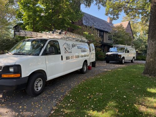 Several trucks from Mike's Window and Gutter Cleaning parked in driveway of Kansas City home